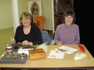 2 women sitting at a table needle felting